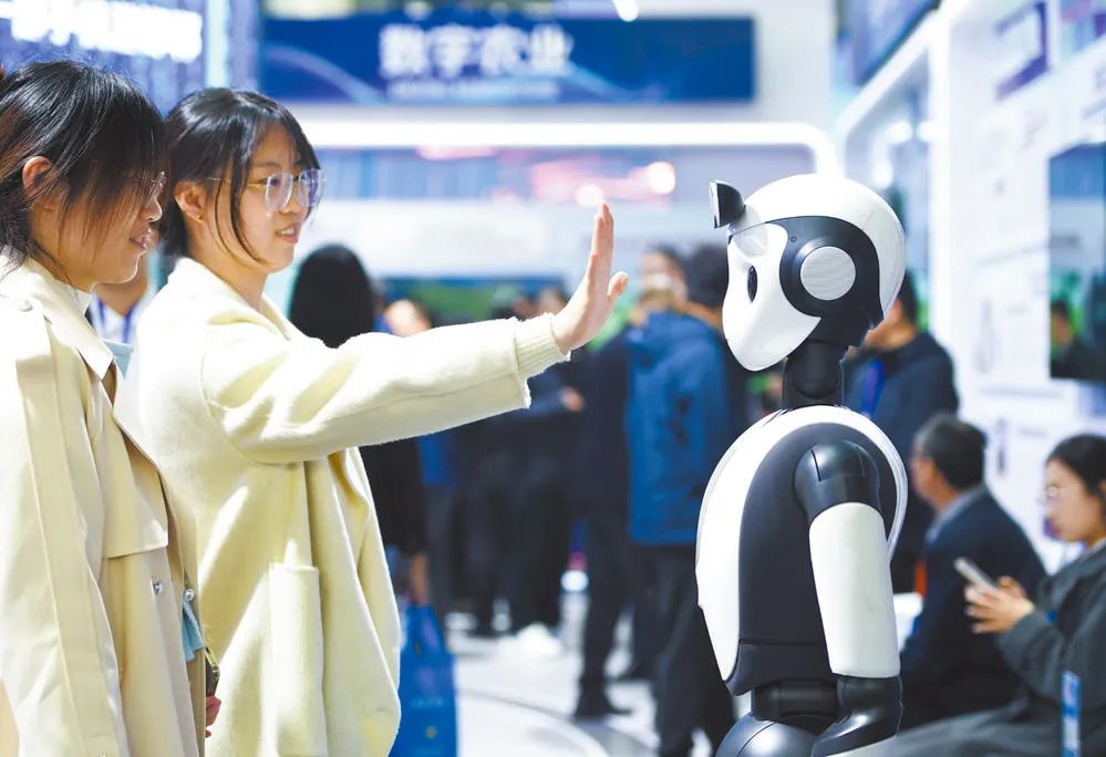 ↑ 参观者在展厅与人工智能机器人互动。